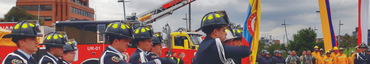 Bomberos con la bandera de Colombia